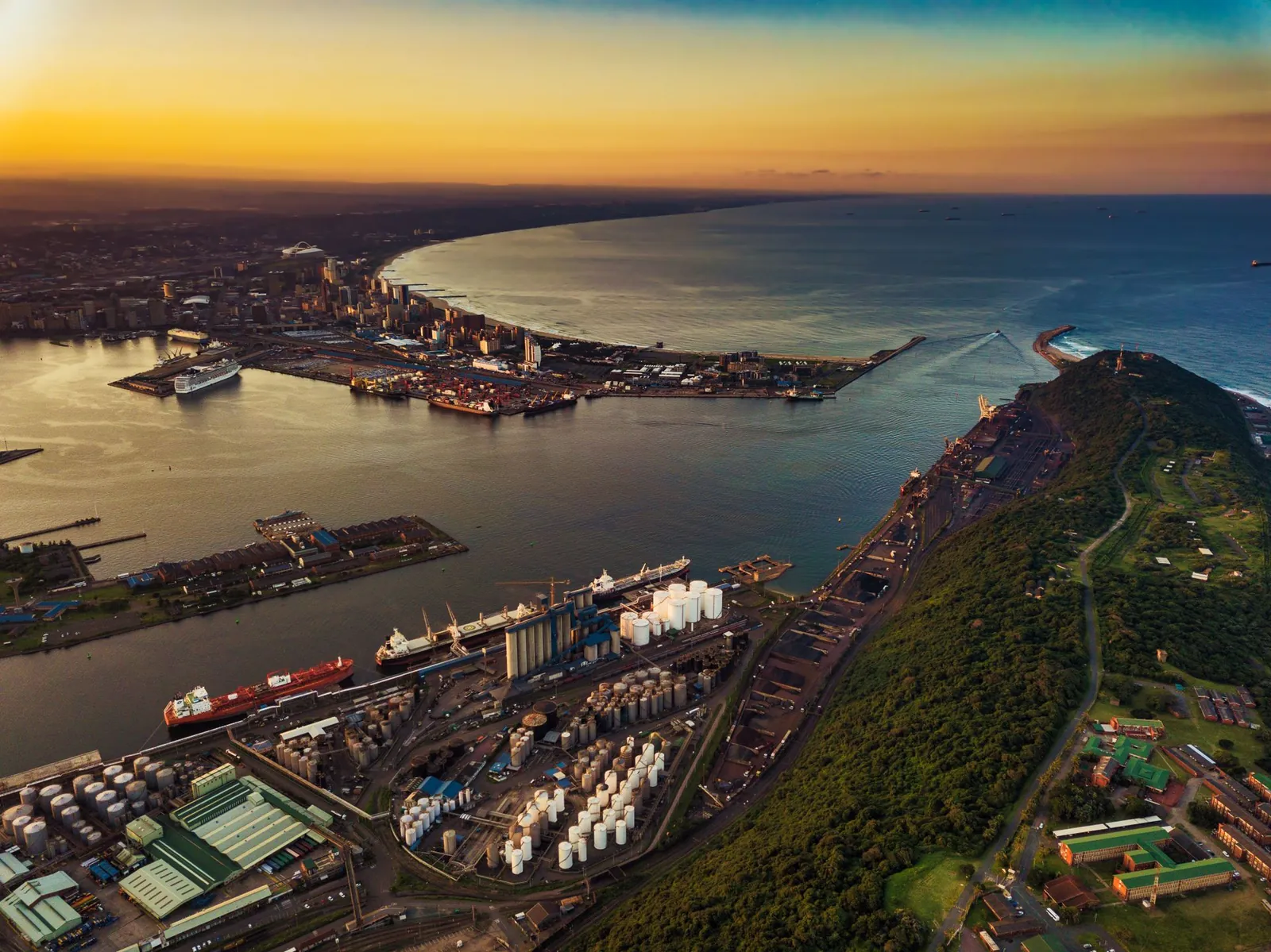 Aerial view of a South African port city and its shoreline at sunrise.