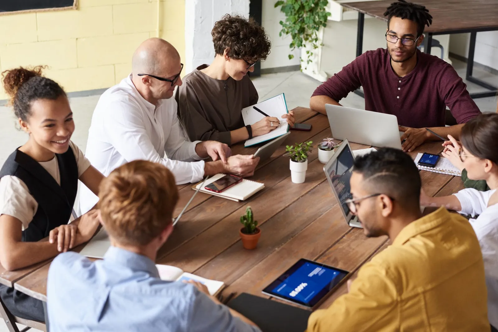 A cross-disciplinary team working through plans and priorities together around a table.
